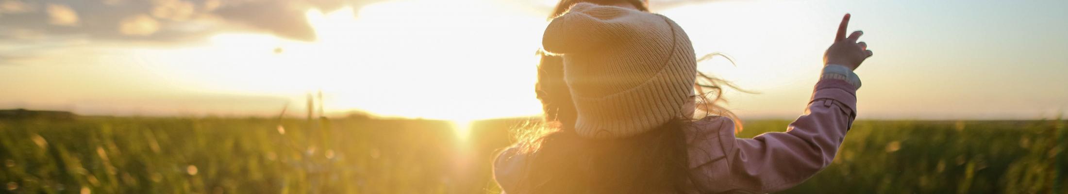 Sunset behind a mother and child in a field