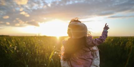 Sunset behind a mother and child in a field