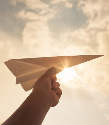 Paper airplane with sky in background