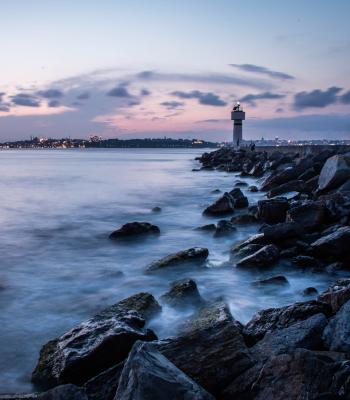 Lighthouse in distance passed rocks