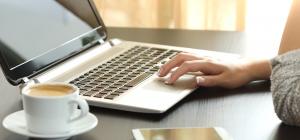 Open laptop with coffee cup and phone